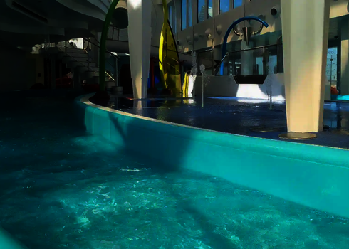 Lazy River mit Wasserattraktionen, bunten Wasserspielen und Wasserdüsen.