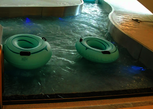 Zwei Rutschreifen treiben im Wasserstrom des Indoor-Lazy-Rivers.