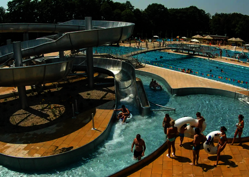 Ein Wasserpark mit einer Lazy River Edelstahl-Wasserrutsche und Badegästen mit Rutschreifen.